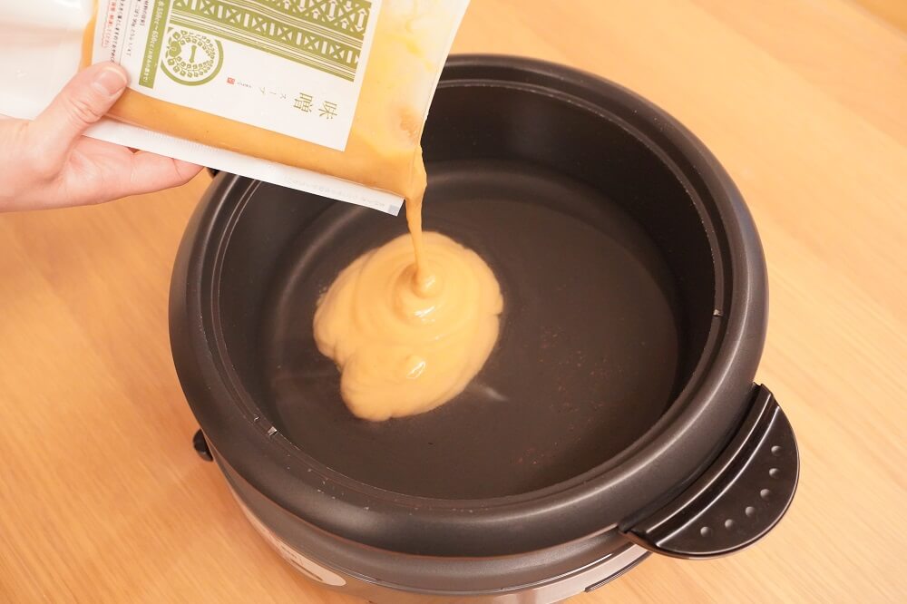 一藤秘伝の濃縮味噌スープを鍋に全部入れる